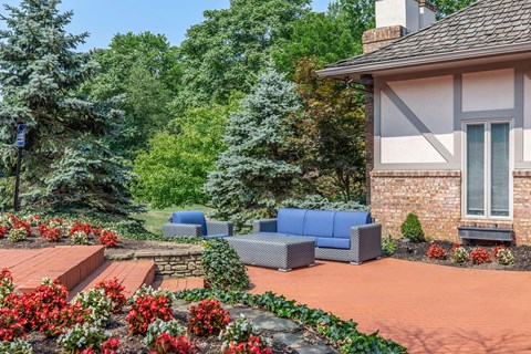 a patio with blue couches in front of a house