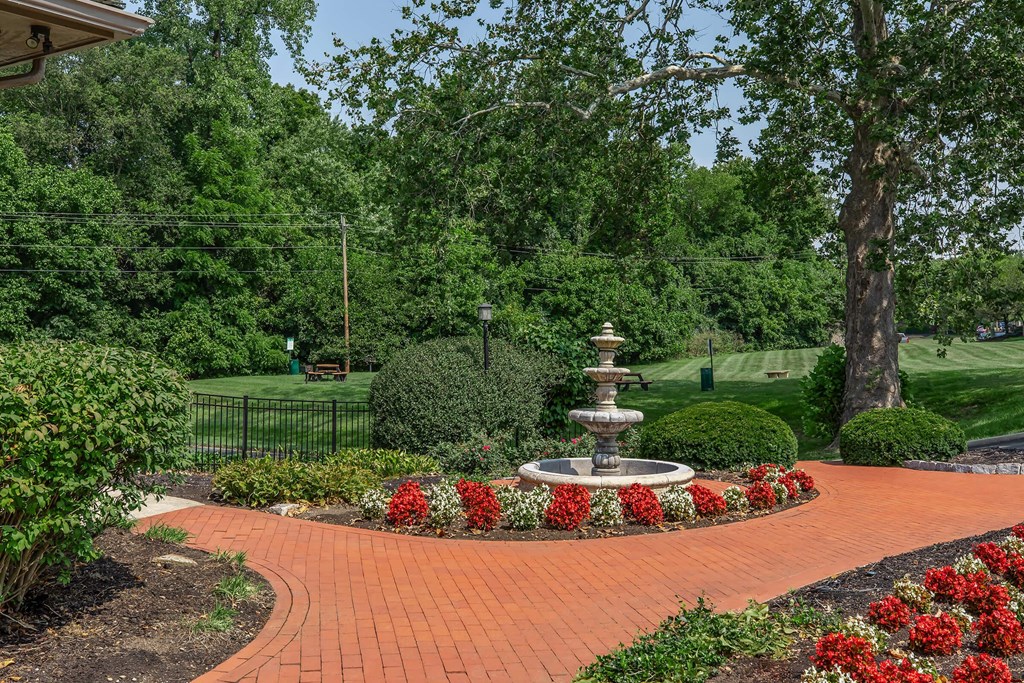 a fountain in the center of a brick walkway