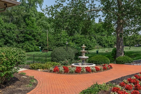 a fountain in the center of a brick walkway