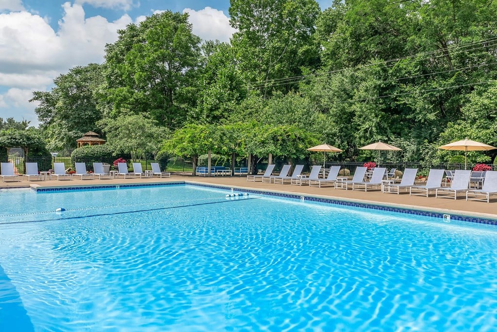 a swimming pool with chairs and umbrellas at the resort