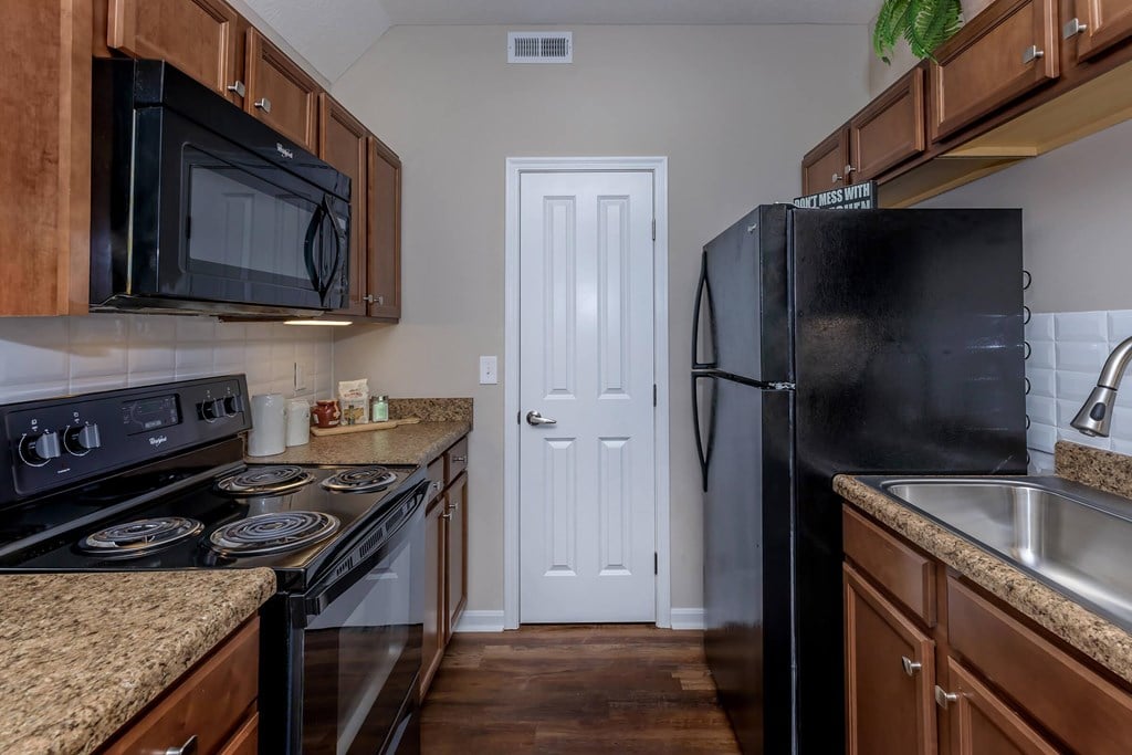 a kitchen with black appliances and granite counter tops