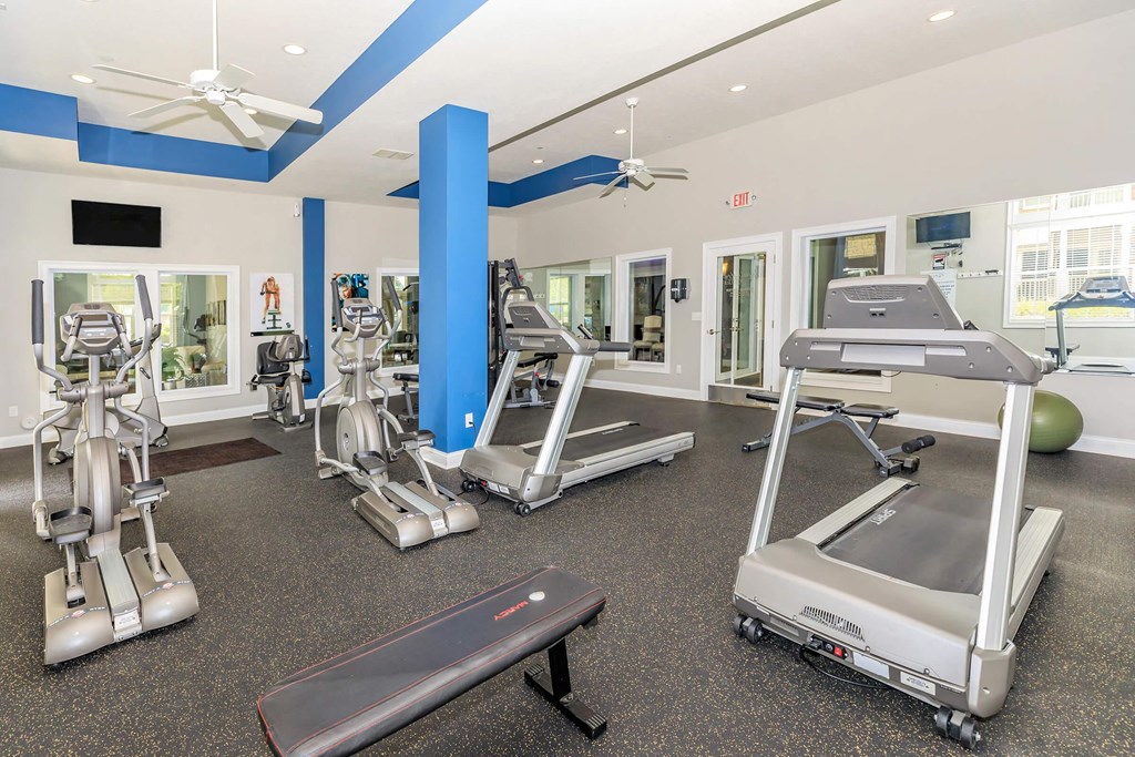 a gym with treadmills and other exercise equipment at the enclave at university crossings