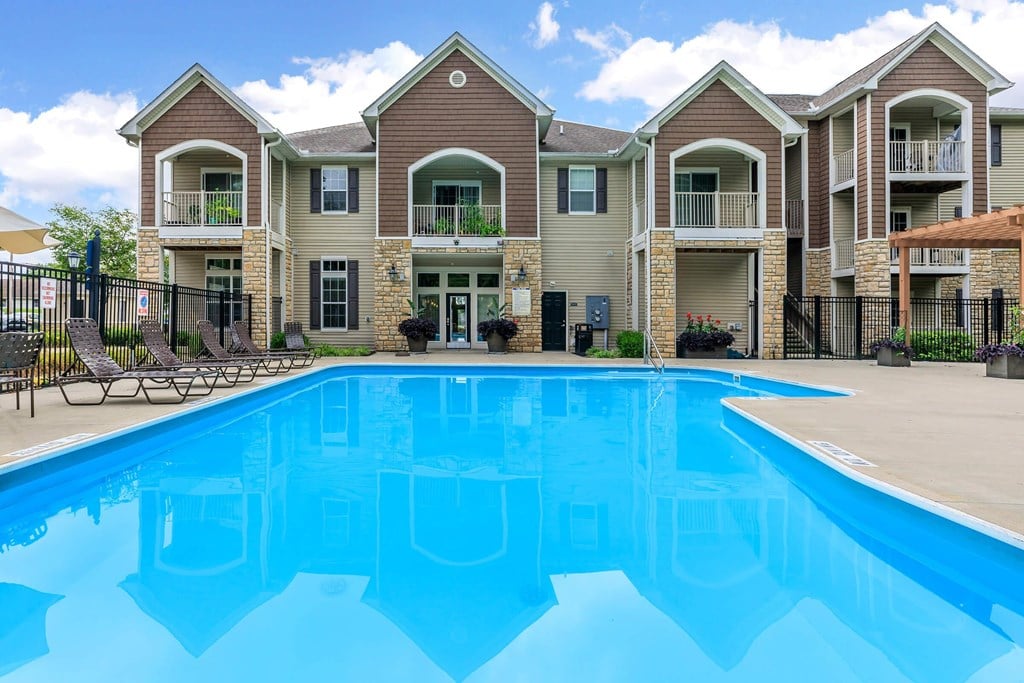 a large swimming pool in front of an apartment building