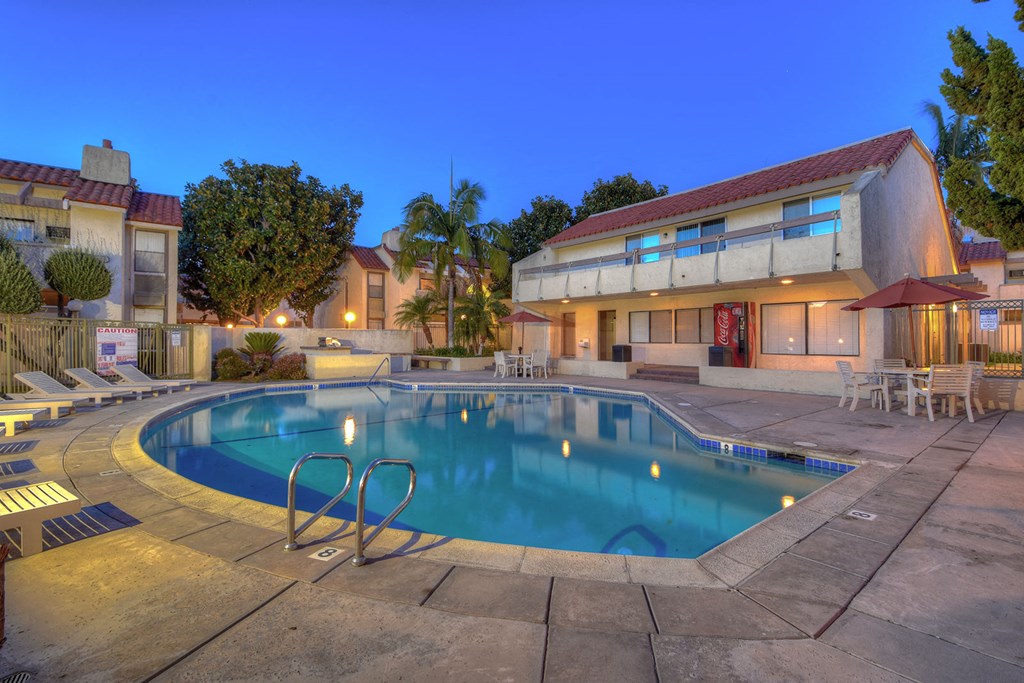 a swimming pool in front of a hotel at night