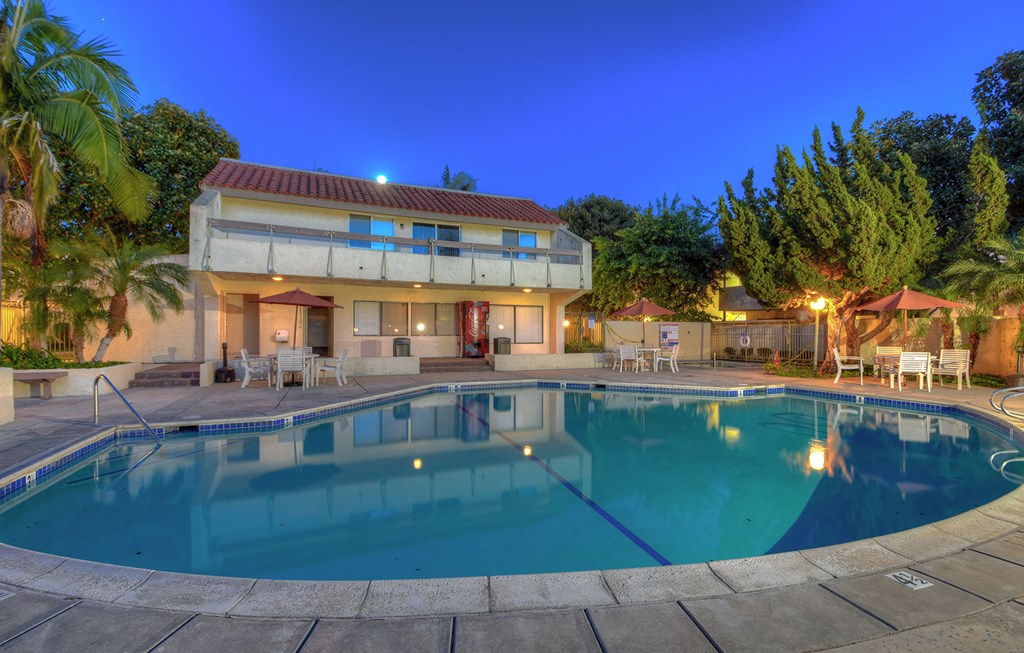 a swimming pool in front of a house with a pool