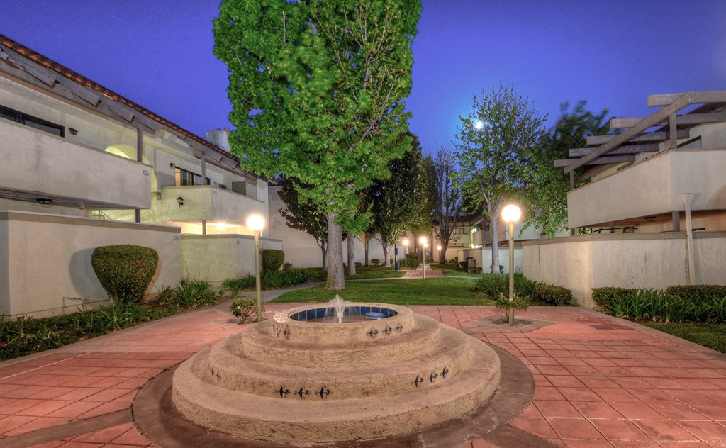 a courtyard with a fountain in the middle of an apartment building