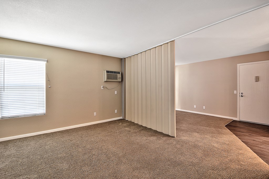 an empty living room with a door to a closet