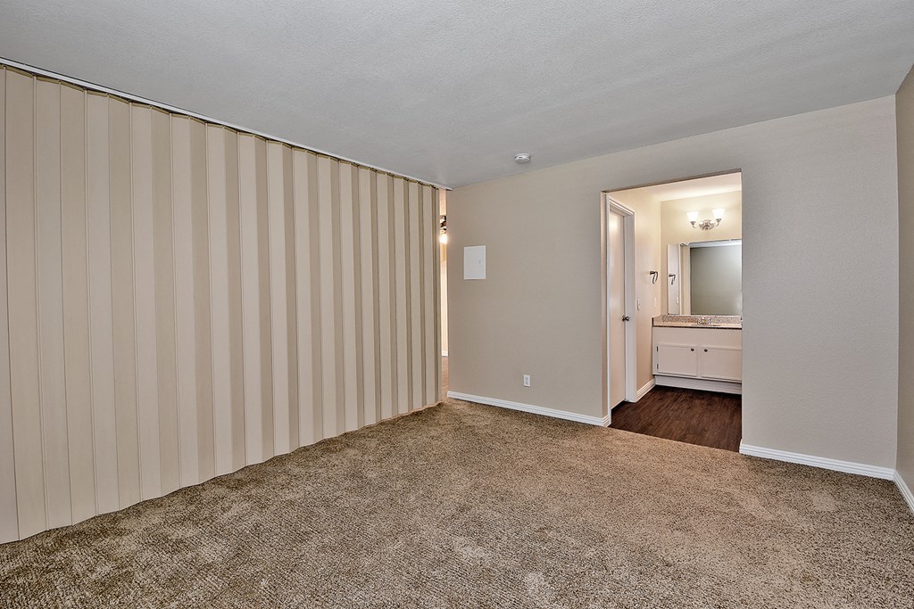 an empty living room with striped walls and a bathroom