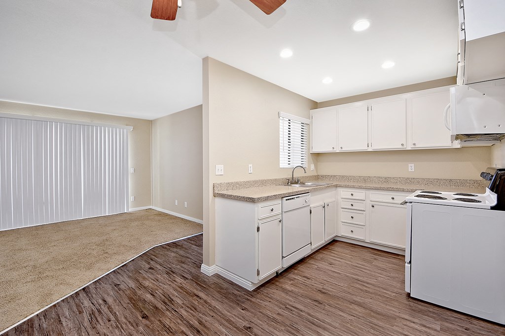 an empty kitchen with white cabinets and white appliances
