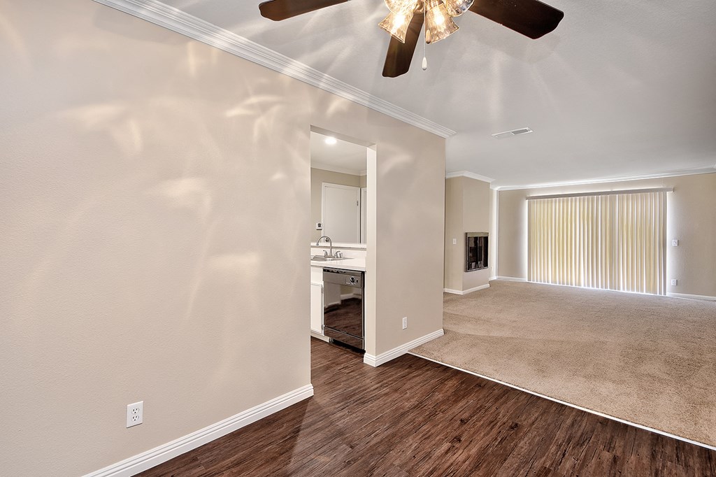 an empty living room with a ceiling fan and a bathroom
