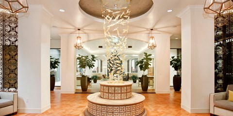 A large, modern sculpture is the centerpiece of a spacious, well-lit lobby.