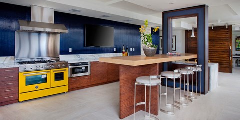 A kitchen with a yellow oven and a blue wall.