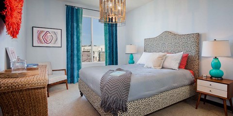 A bedroom with a large bed and a chandelier.