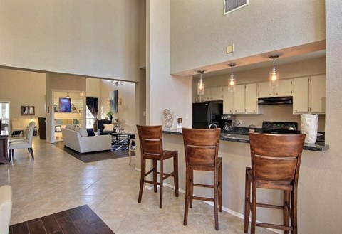 A kitchen with a bar stool and a counter.