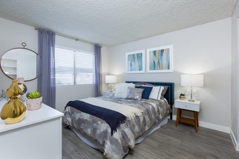 A bedroom with a bed, nightstand, and lamp.