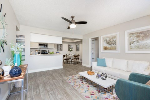 A living room with a white couch and a ceiling fan.