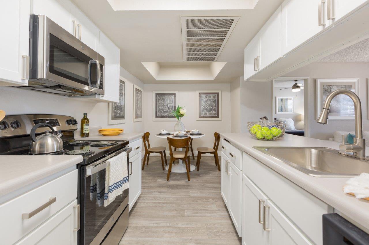 A kitchen with white cabinets and a black stove top oven.