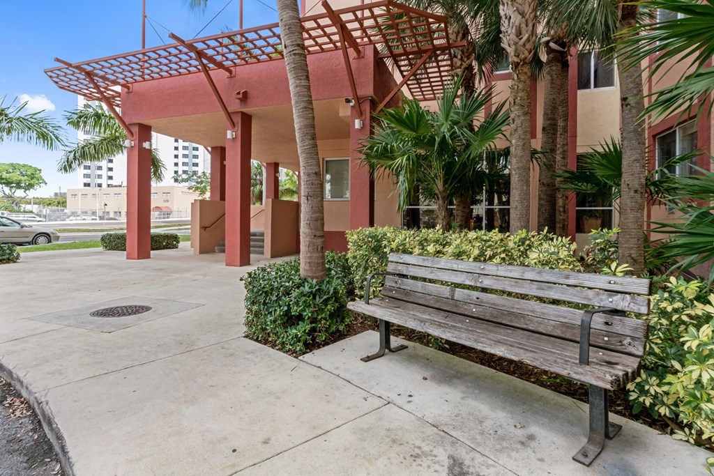 a bench in front of a building with palm trees
