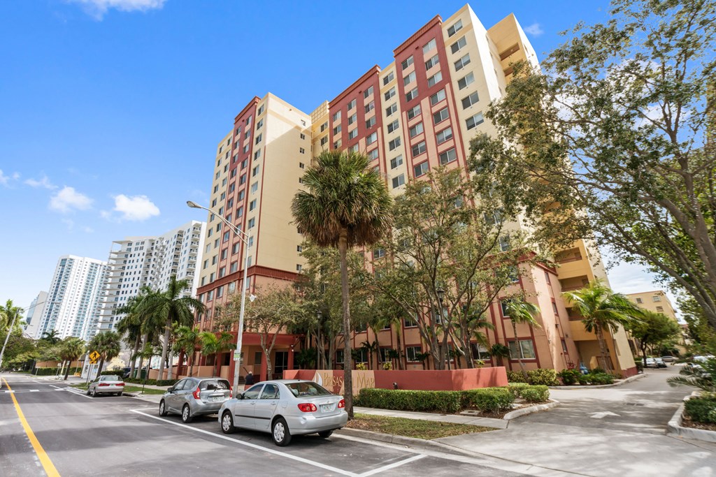a city street with cars parked in front of tall buildings