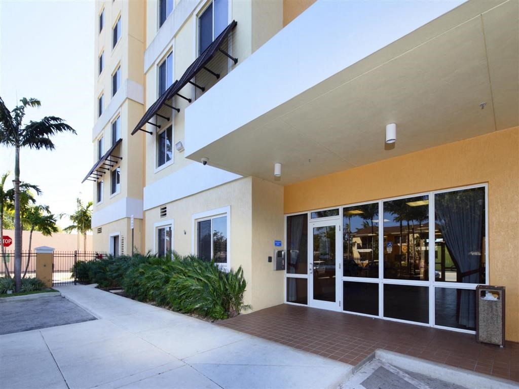 the entrance to a building with glass doors and a sidewalk