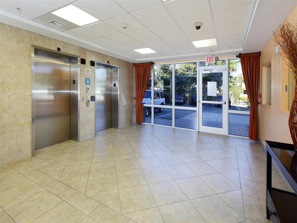 the lobby of a building with doors and a tiled floor