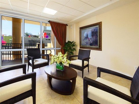 a living room with a table and chairs and a balcony