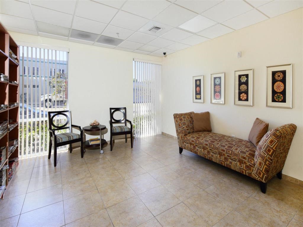 a living room with a couch and chairs and a balcony