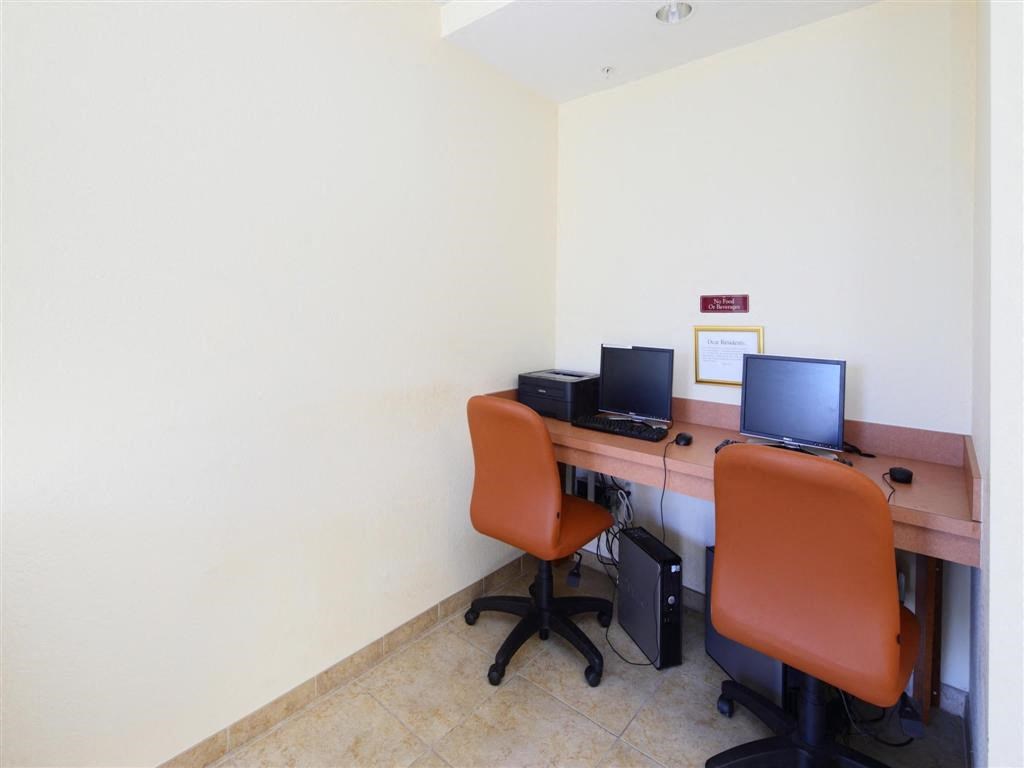 a computer room with two chairs and a desk with computers