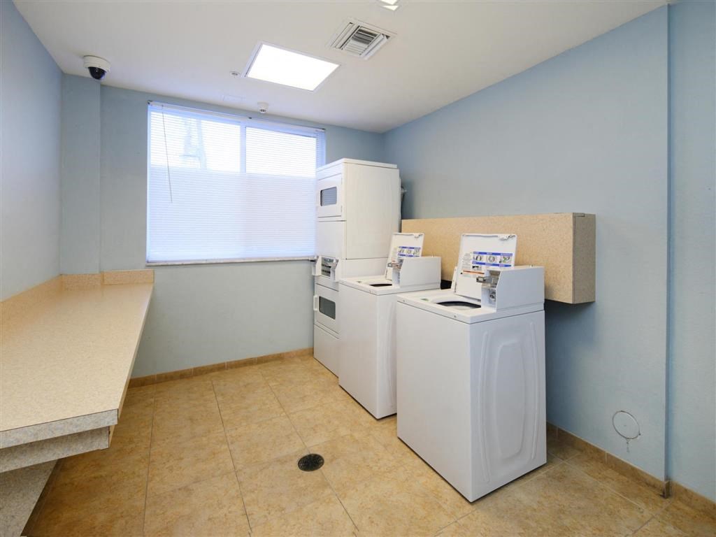 a laundry room with two washing machines and a window