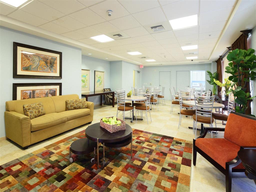 a common room with tables and chairs and a couch