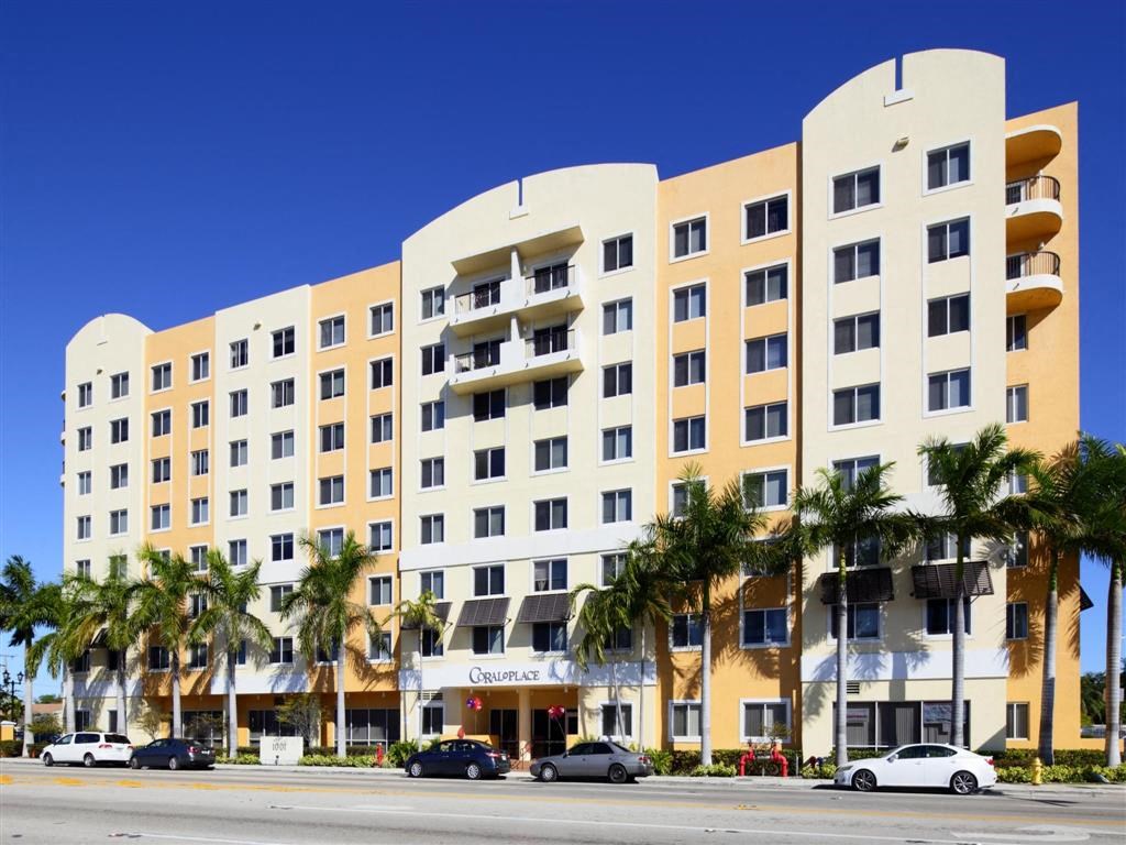 a building with palm trees in front of it on a street