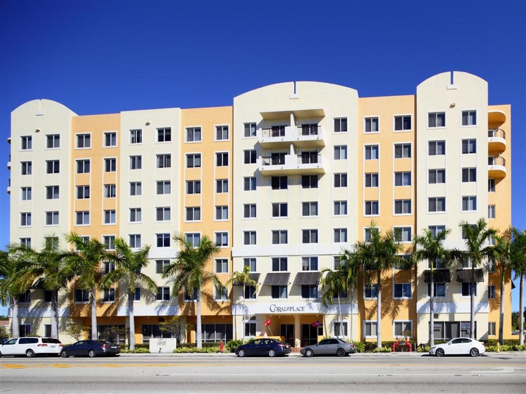 a large hotel building with palm trees in front of it