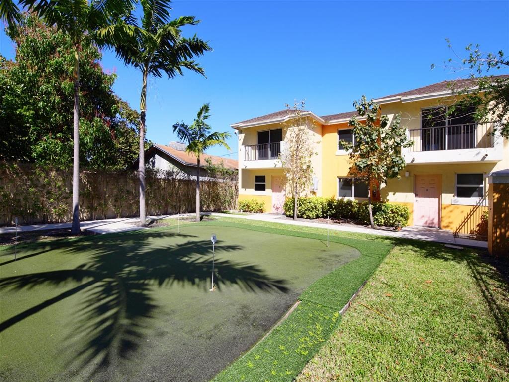 a yard with a golf hole in front of a house