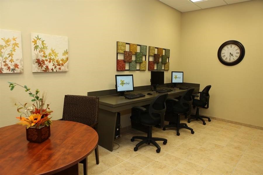 a room with a table with computers and a clock on the wall