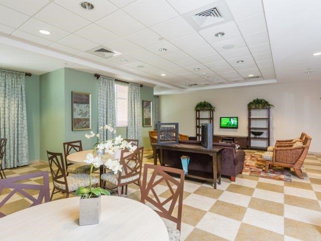 a living room with a table and chairs and a piano