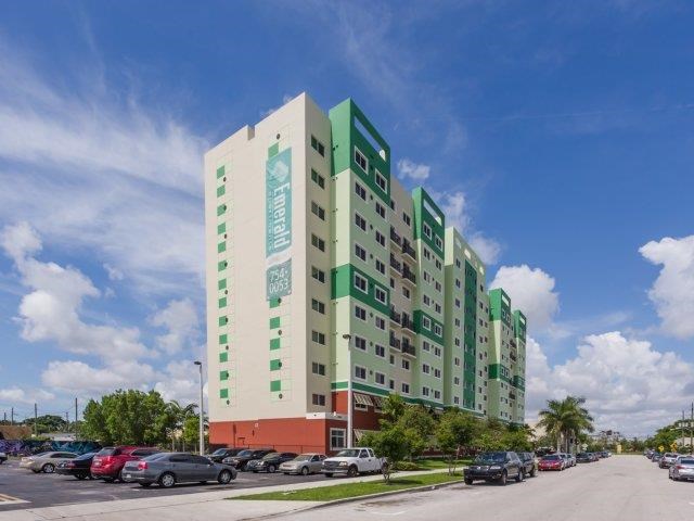 a tall building with cars parked in front of it