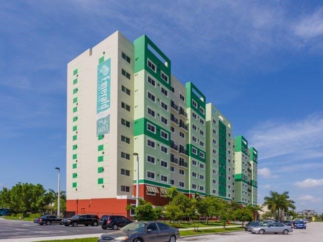 a tall building with cars parked in front of it