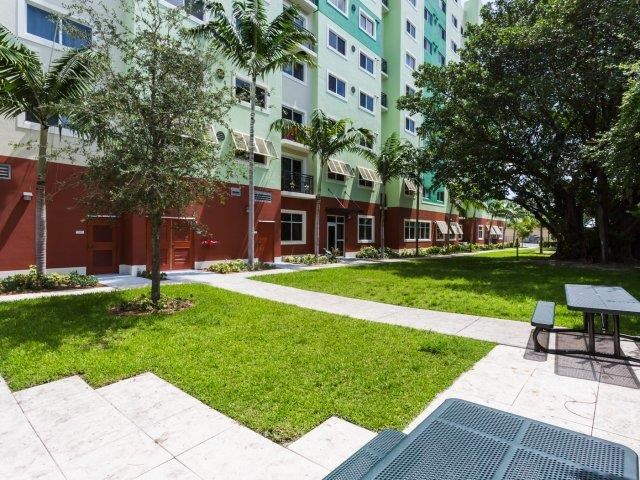 a courtyard of an apartment building with grass and trees