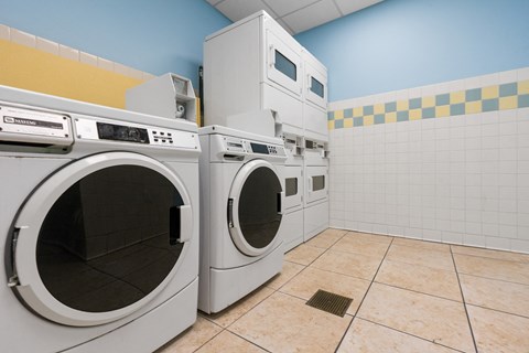 a laundry room with washes and dryers in a laundromat
