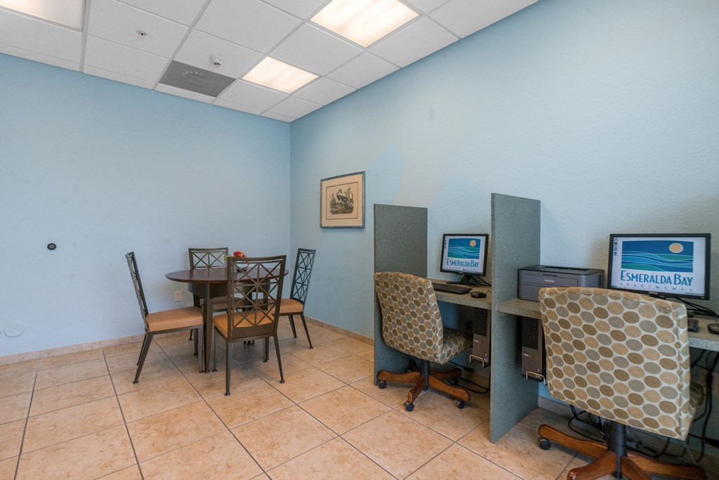 a room with a table with chairs and a desk with a computer