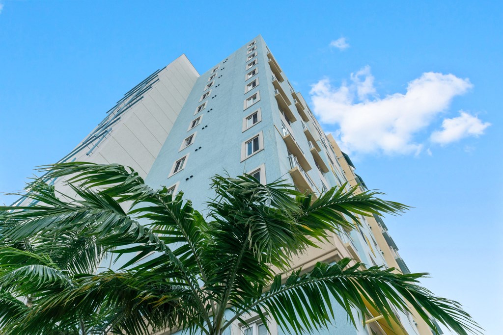 a tall building with palm trees in front of it