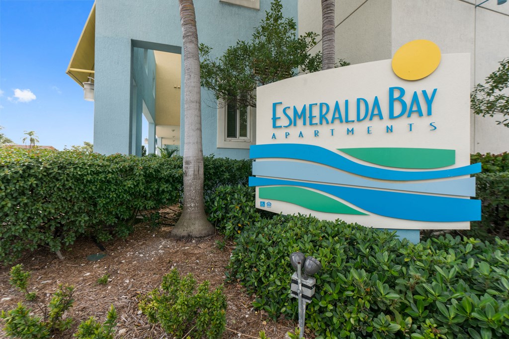 the sign for emerald bay apartments in front of the building