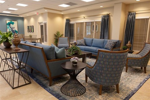 a living room with blue couches and chairs and a table
