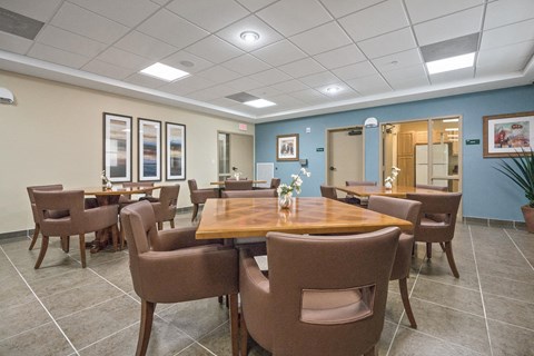a dining room with tables and chairs and a kitchen