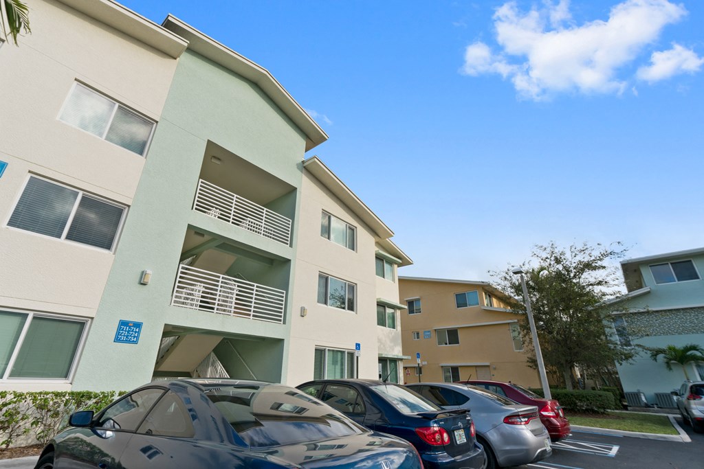 an apartment building with a parking lot full of cars