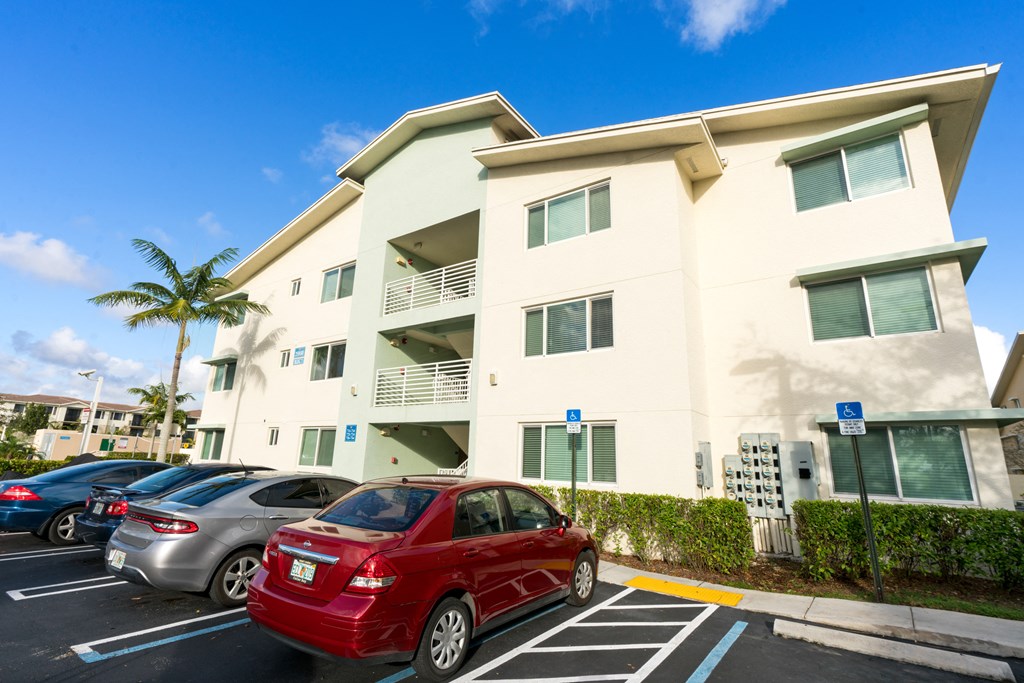 an apartment building with cars parked in front of it