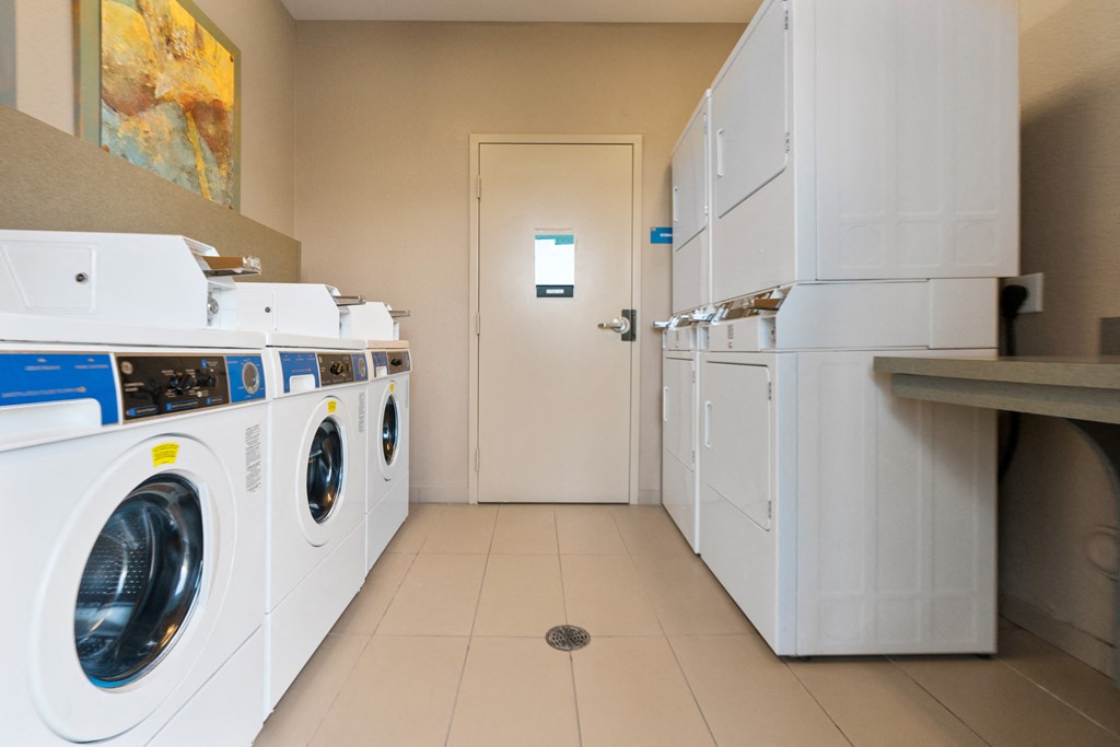 a laundry room with washes and dryers and a door to a bathroom