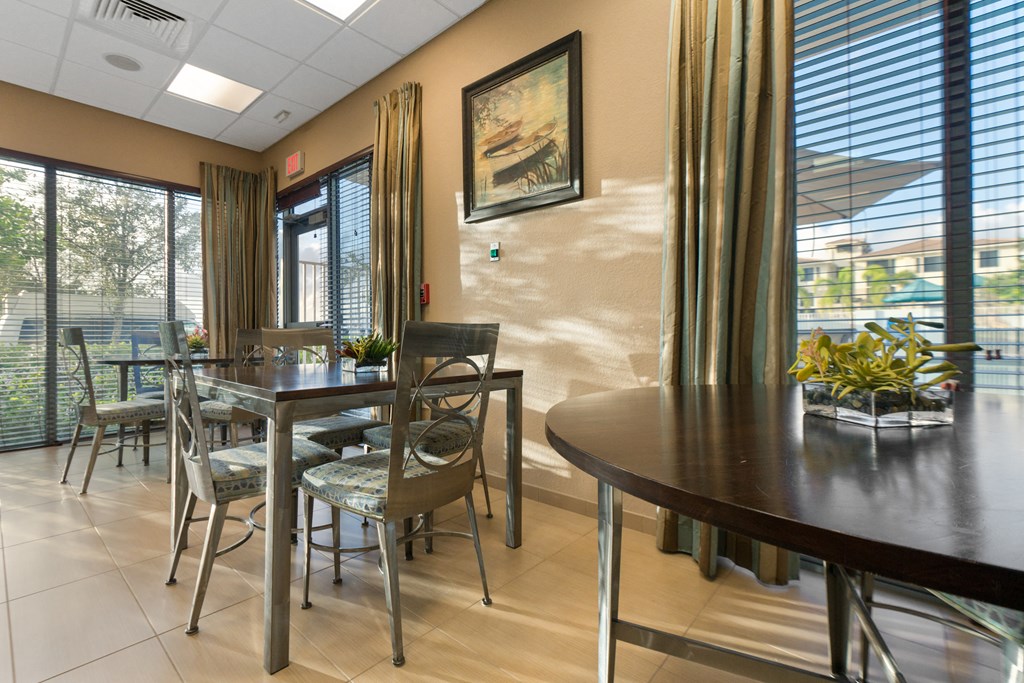 a dining room with a table and chairs and windows