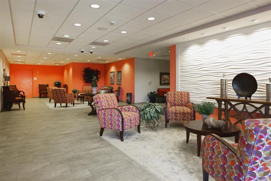 a lobby with chairs and tables in a building