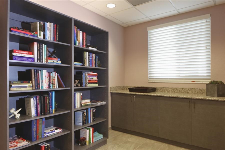 a room with bookshelves and a counter and a window